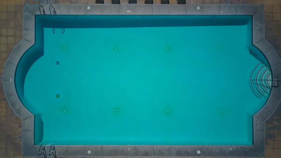 A top-down shot of a clear swimming pool, perfect for summer relaxation.